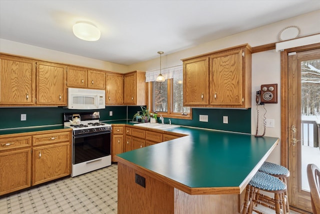 kitchen with kitchen peninsula, pendant lighting, white appliances, and sink