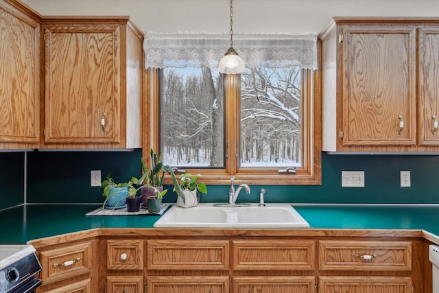 kitchen with range, hanging light fixtures, and sink