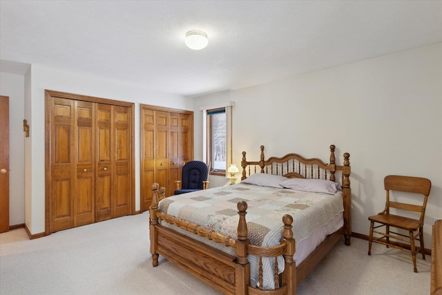 bedroom featuring carpet flooring and two closets