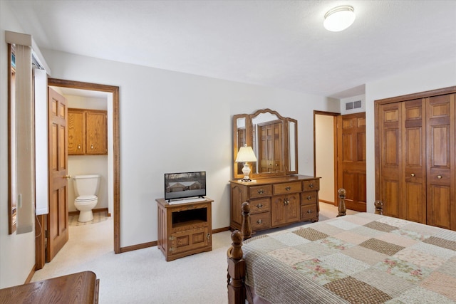 carpeted bedroom featuring ensuite bath and a closet