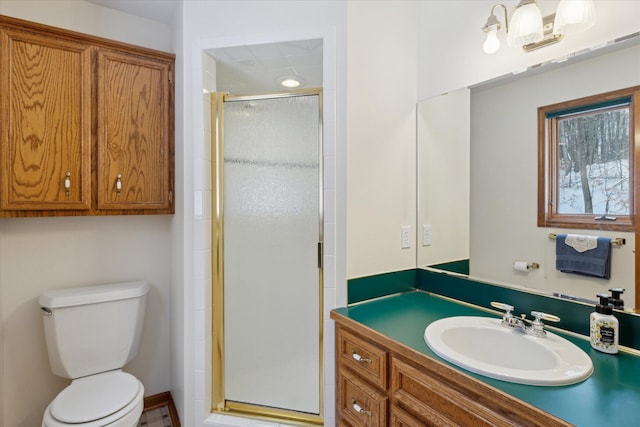 bathroom featuring vanity, toilet, and a shower with shower door