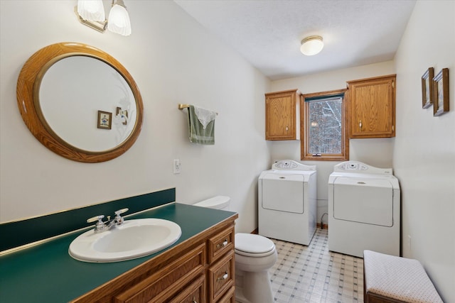 bathroom featuring vanity, toilet, independent washer and dryer, and a textured ceiling