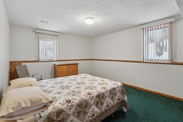 bedroom with carpet floors and a textured ceiling