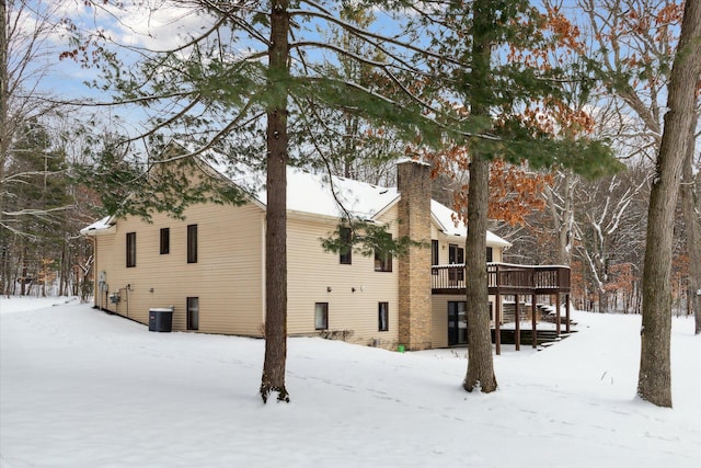 snow covered property featuring a deck and cooling unit