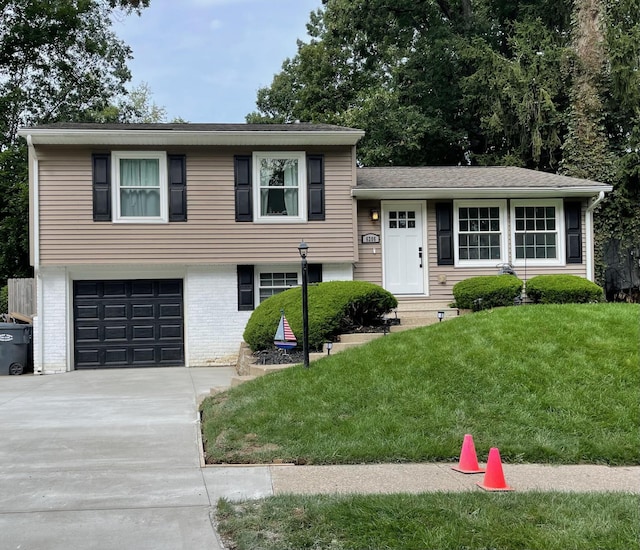 tri-level home featuring a garage and a front yard