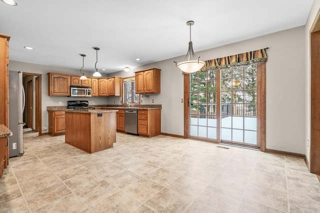 kitchen with plenty of natural light, pendant lighting, a center island, and stainless steel appliances