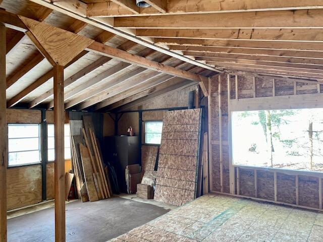 misc room with vaulted ceiling and water heater