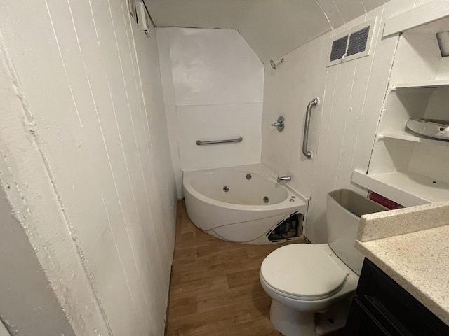 bathroom featuring vanity, hardwood / wood-style flooring, toilet, and a bathtub