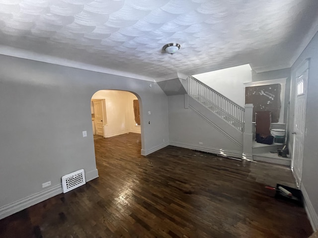 unfurnished living room featuring dark hardwood / wood-style floors and a textured ceiling