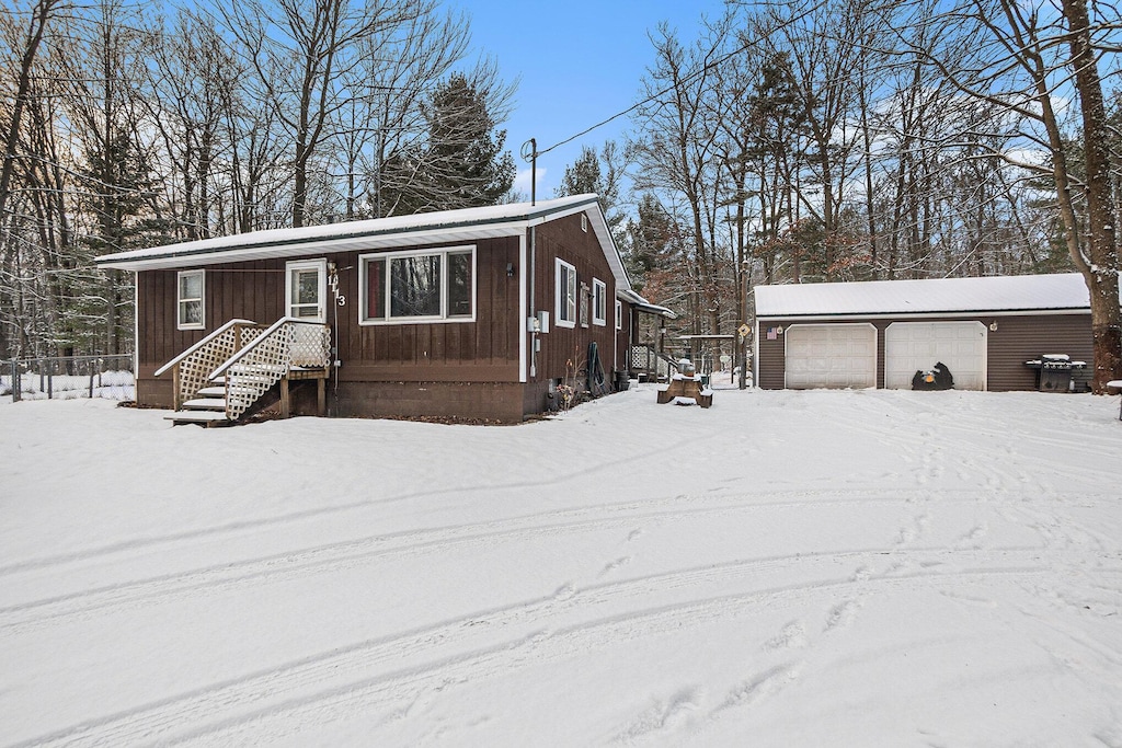 view of front of house featuring a garage and an outbuilding