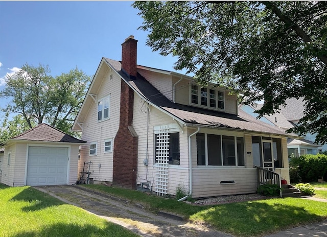 view of front facade featuring a front yard, a garage, and an outdoor structure