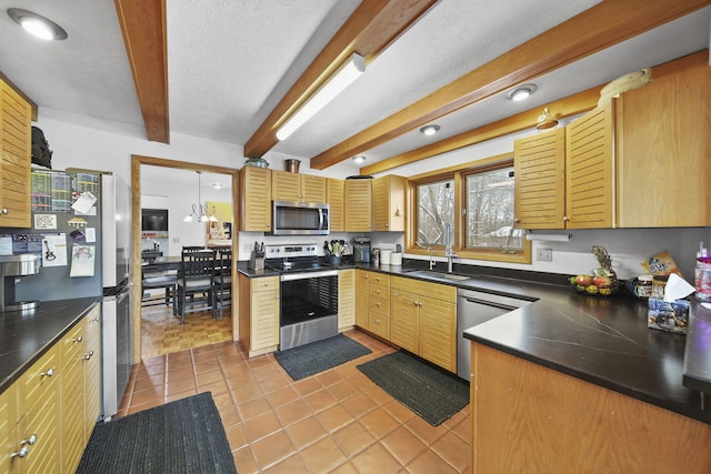 kitchen with appliances with stainless steel finishes, sink, pendant lighting, beam ceiling, and light tile patterned flooring