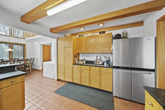 kitchen featuring refrigerator, beamed ceiling, stainless steel refrigerator, hanging light fixtures, and light tile patterned flooring