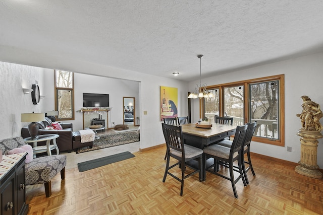 dining space with light parquet floors, an inviting chandelier, plenty of natural light, and a brick fireplace