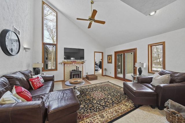 living room featuring carpet, high vaulted ceiling, a wood stove, and ceiling fan