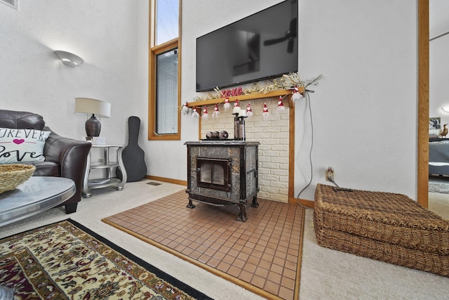 living room featuring light colored carpet and a wood stove