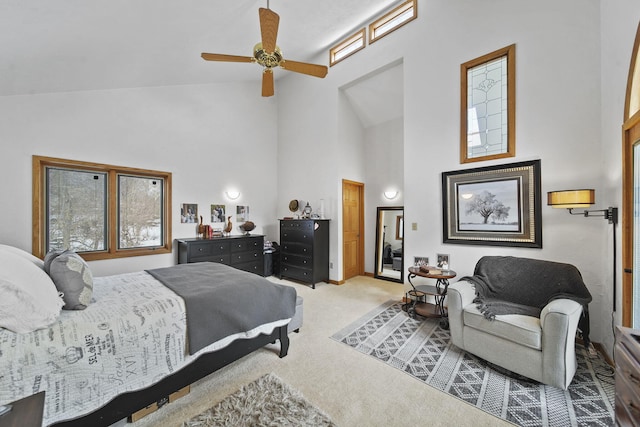 carpeted bedroom with ceiling fan and high vaulted ceiling