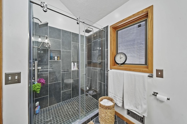 bathroom featuring a textured ceiling and walk in shower