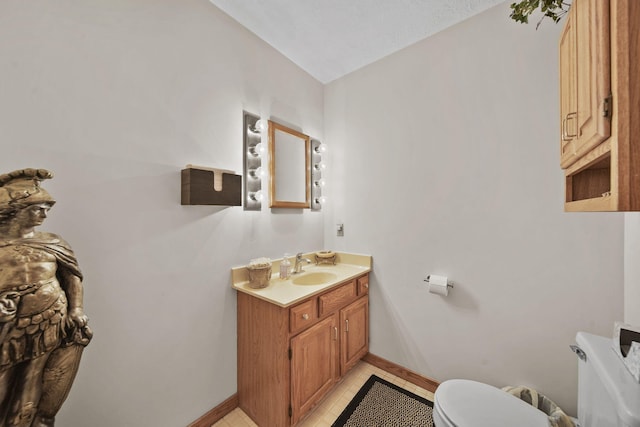 bathroom featuring tile patterned flooring, vanity, and toilet