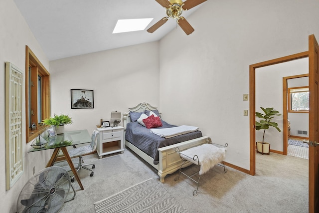 carpeted bedroom with lofted ceiling with skylight and ceiling fan