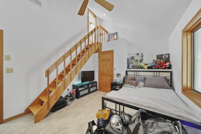 bedroom featuring ceiling fan, high vaulted ceiling, and light colored carpet