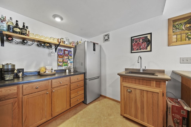 kitchen featuring stainless steel fridge and sink