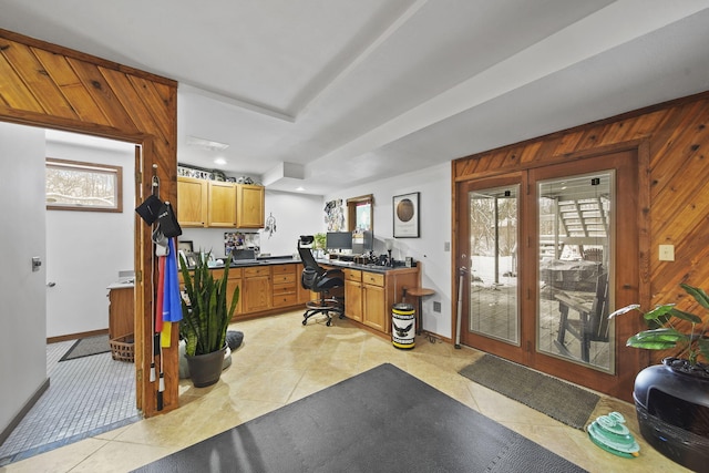 tiled office space featuring built in desk and wood walls