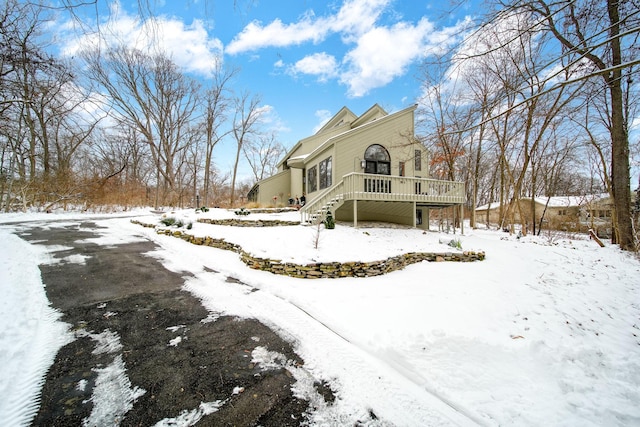 snow covered back of property with a deck