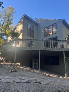 rear view of house featuring a wooden deck