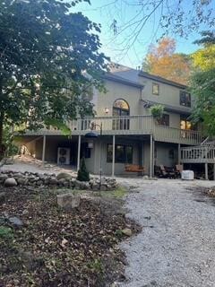 rear view of property featuring a wooden deck