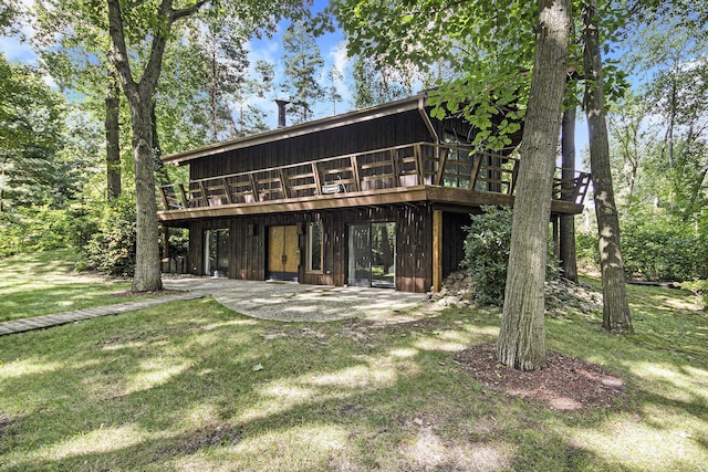 back of property featuring a lawn, a patio area, and a wooden deck