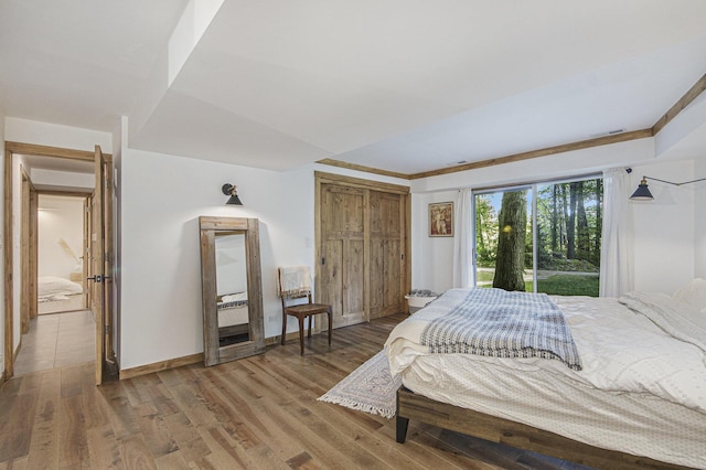 bedroom with access to exterior and hardwood / wood-style floors