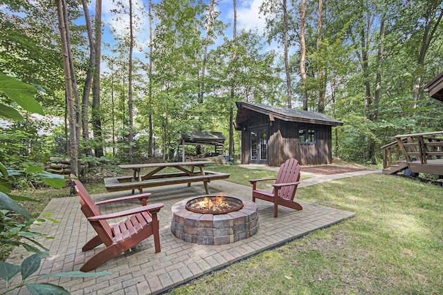 view of yard with a patio area, an outdoor fire pit, and an outdoor structure