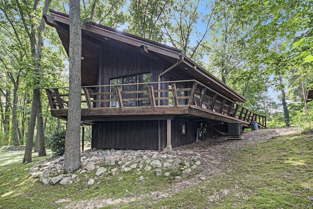 rear view of house with central AC unit and a wooden deck