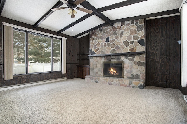 unfurnished living room with carpet, a baseboard heating unit, a stone fireplace, vaulted ceiling with beams, and wooden walls