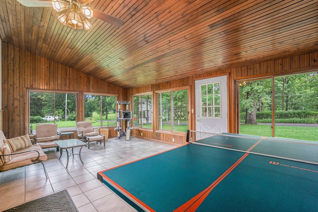 rec room featuring ceiling fan, wooden ceiling, wood walls, lofted ceiling, and light tile patterned floors