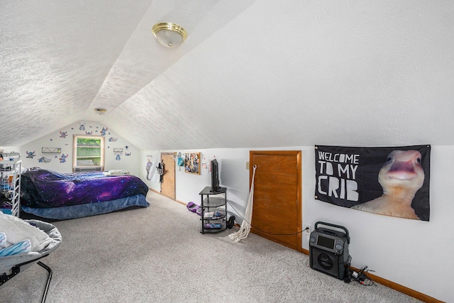 carpeted bedroom featuring lofted ceiling and a textured ceiling