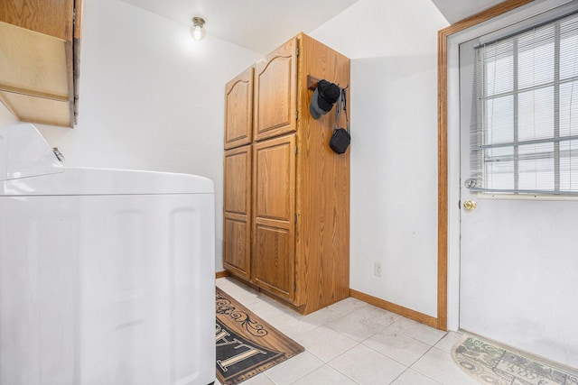 washroom featuring cabinets, washer / clothes dryer, and light tile patterned flooring