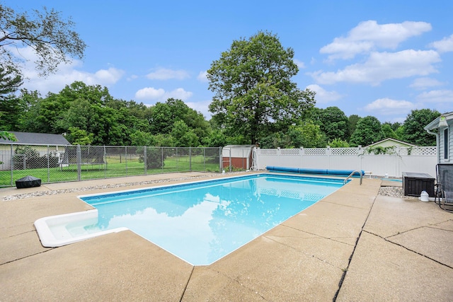 view of pool with central air condition unit and a patio area