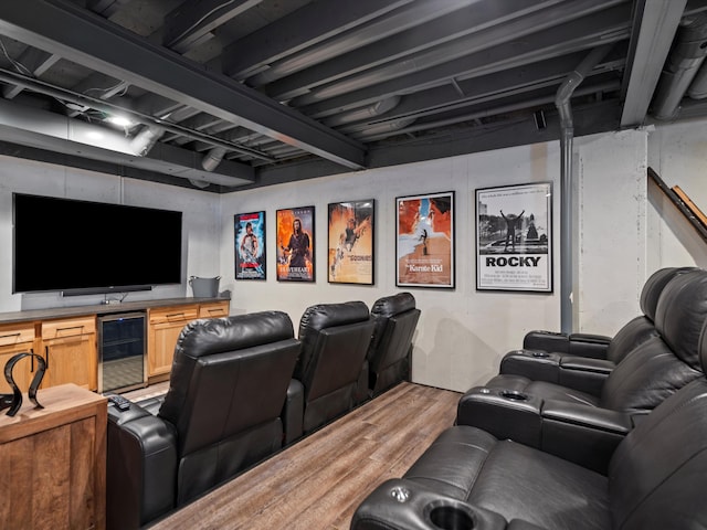 home theater room featuring wood-type flooring, bar area, and wine cooler