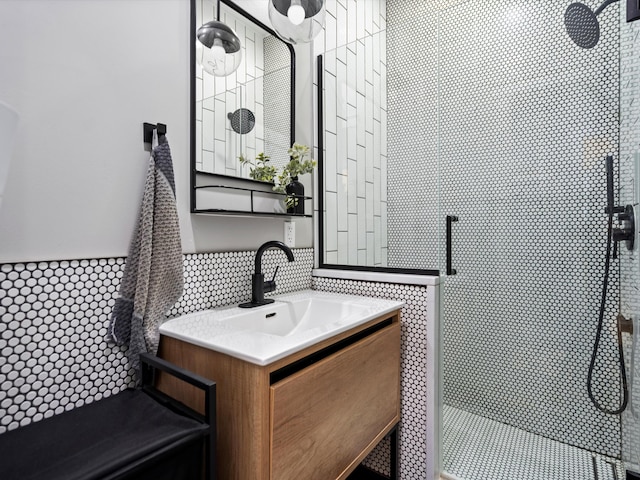 bathroom with decorative backsplash, a tile shower, and vanity