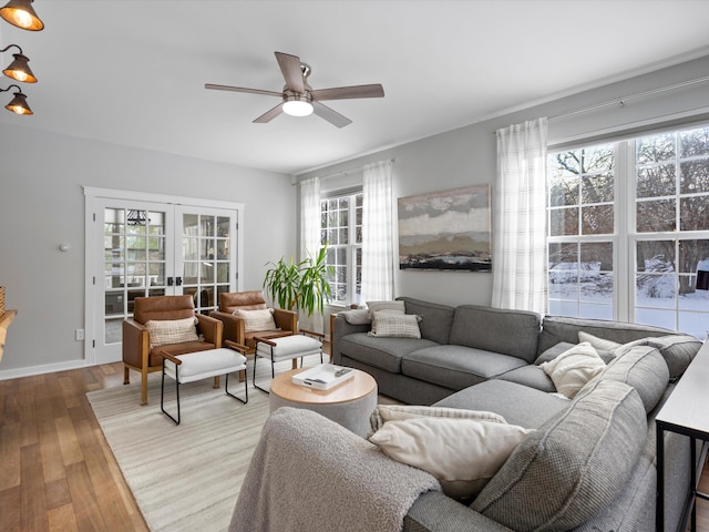 living room with light wood-type flooring, french doors, and ceiling fan