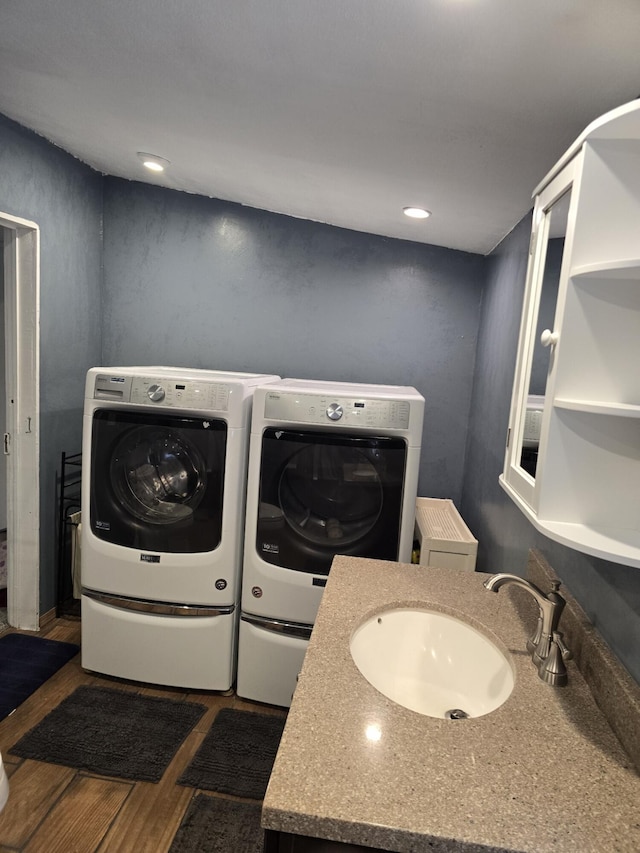 laundry room with sink, washer and dryer, and dark hardwood / wood-style floors