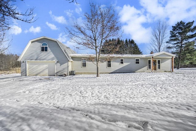 snow covered house with a garage and a porch