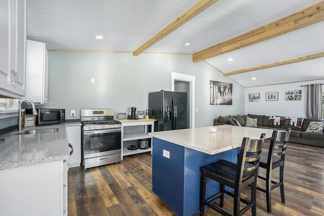 kitchen with lofted ceiling with beams, a center island, stainless steel appliances, white cabinetry, and sink