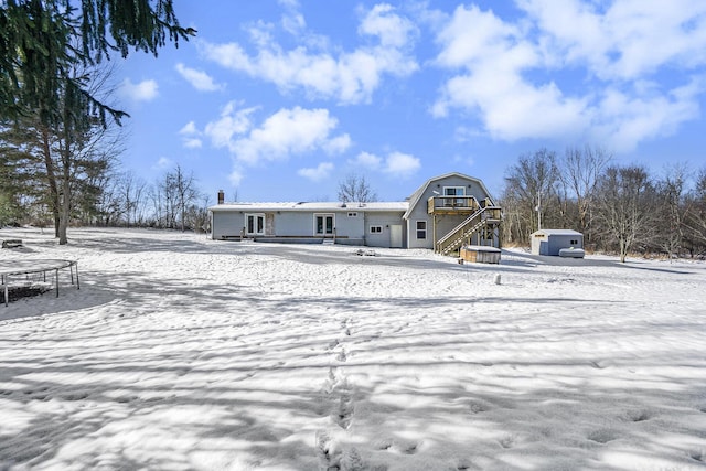 snow covered rear of property featuring a trampoline and a shed