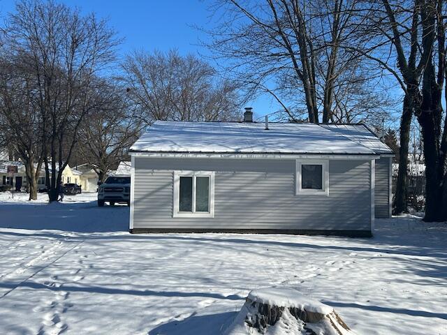 view of snow covered rear of property