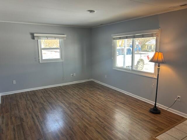 empty room with dark wood-type flooring and ornamental molding