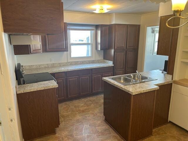 kitchen featuring range, kitchen peninsula, dark brown cabinetry, sink, and exhaust hood