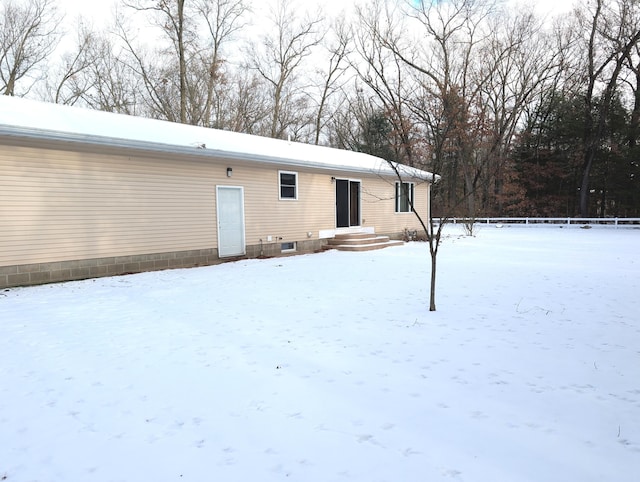 view of snow covered rear of property